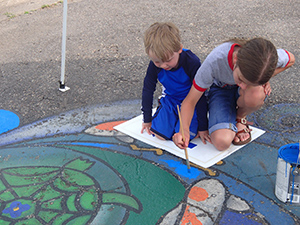 Young volunteers paint the mural